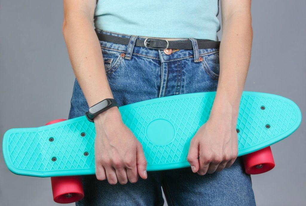 young-slim-woman-in-jeans-holds-plastic-skate-board-in-her-hands-on-a-gray-background-youth-hipster-fashion.jpg